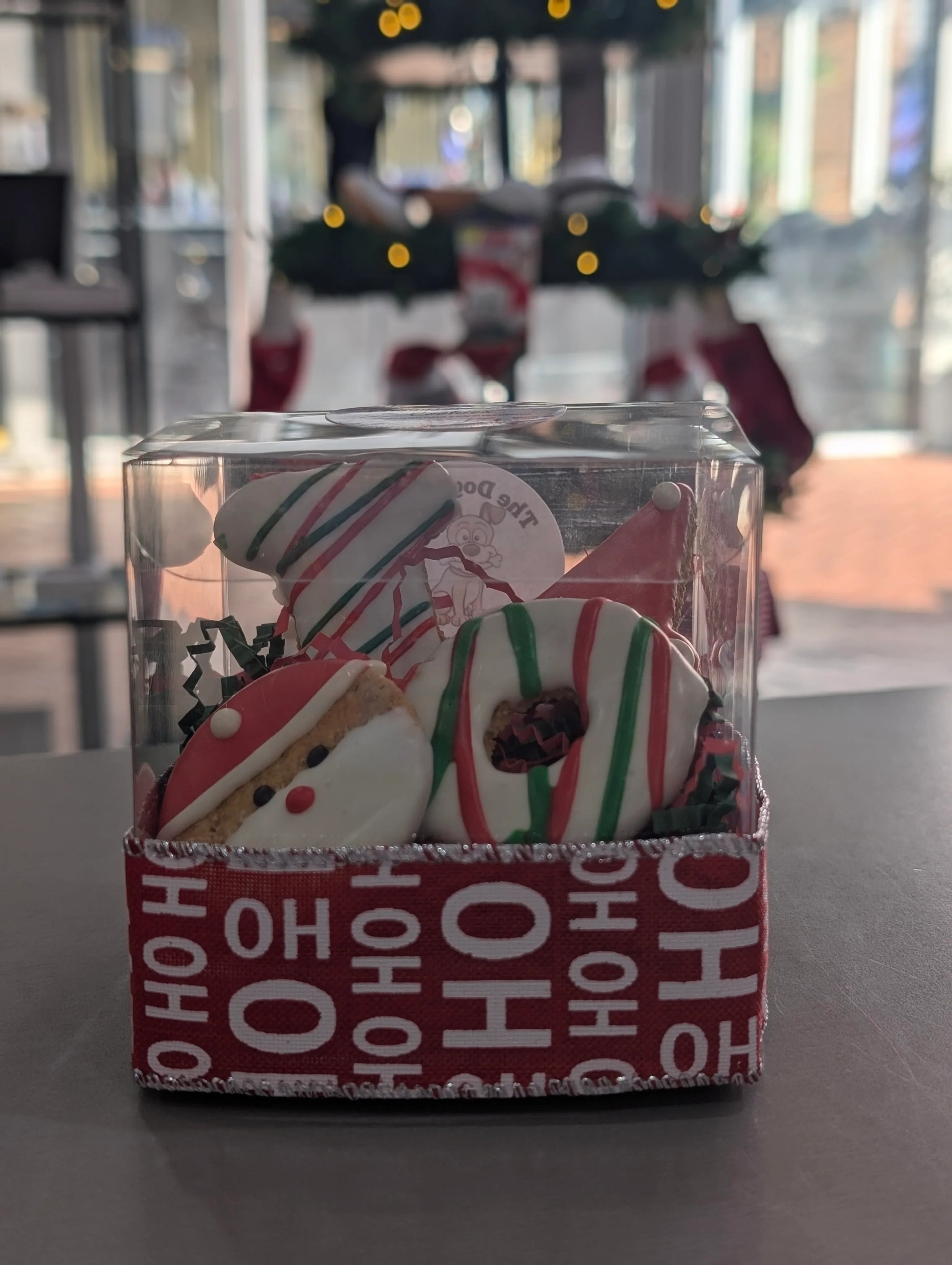 Clear container with Christmas-themed cookies on a table