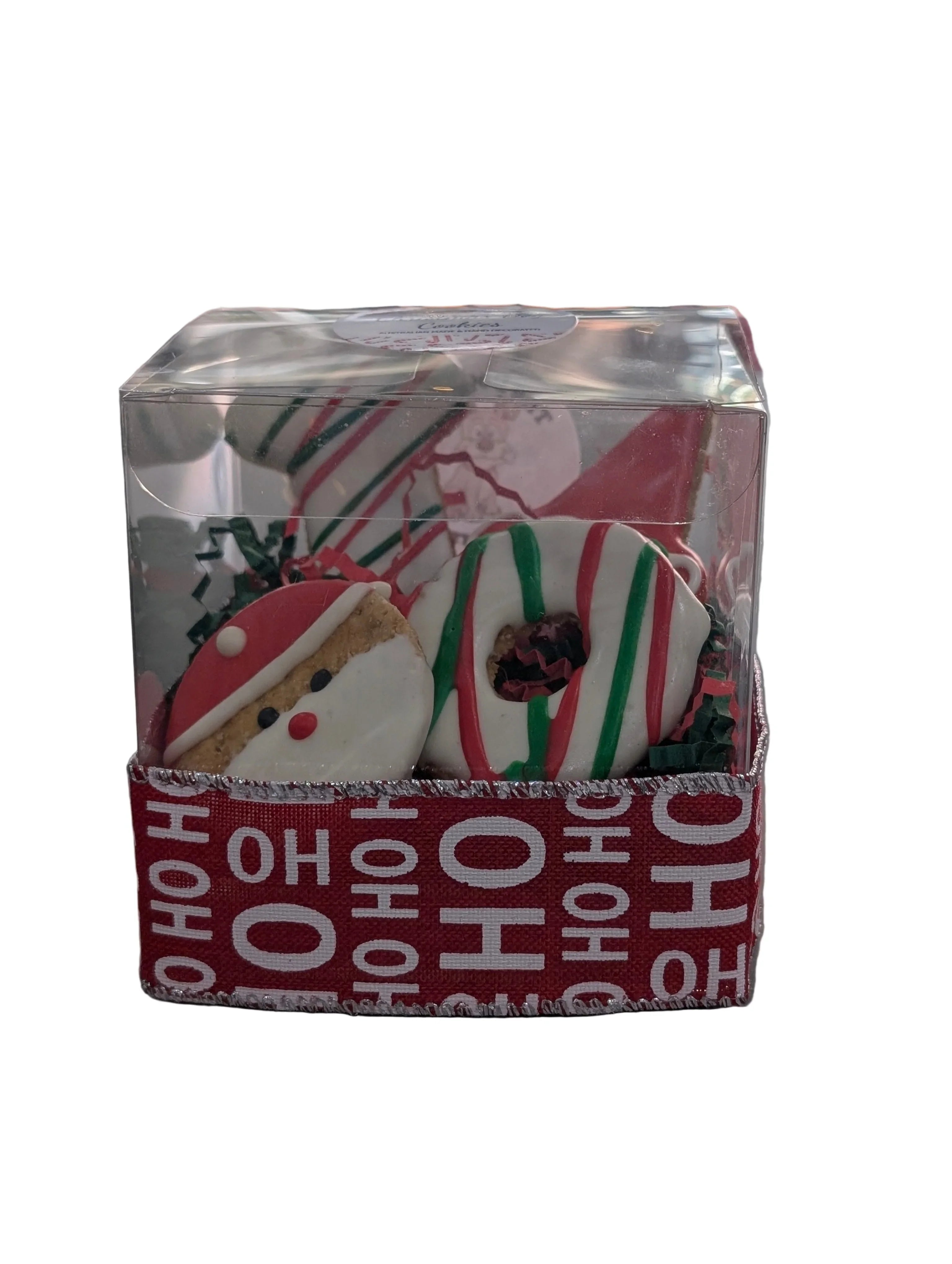 Decorative Christmas cookies in a clear box with 'HO HO HO' text on a reflective surface.