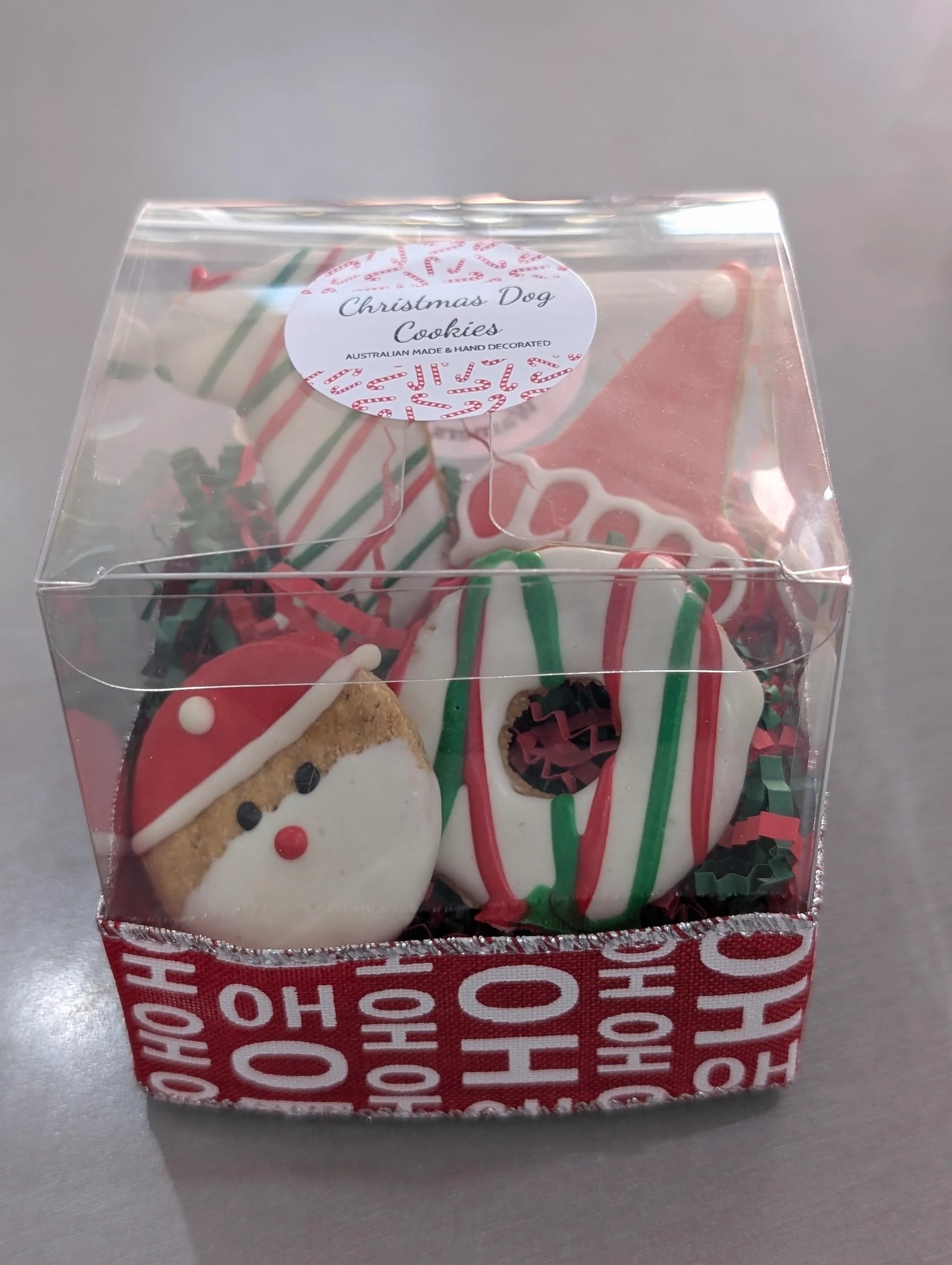 Clear box with Christmas-themed cookies on a gray background
